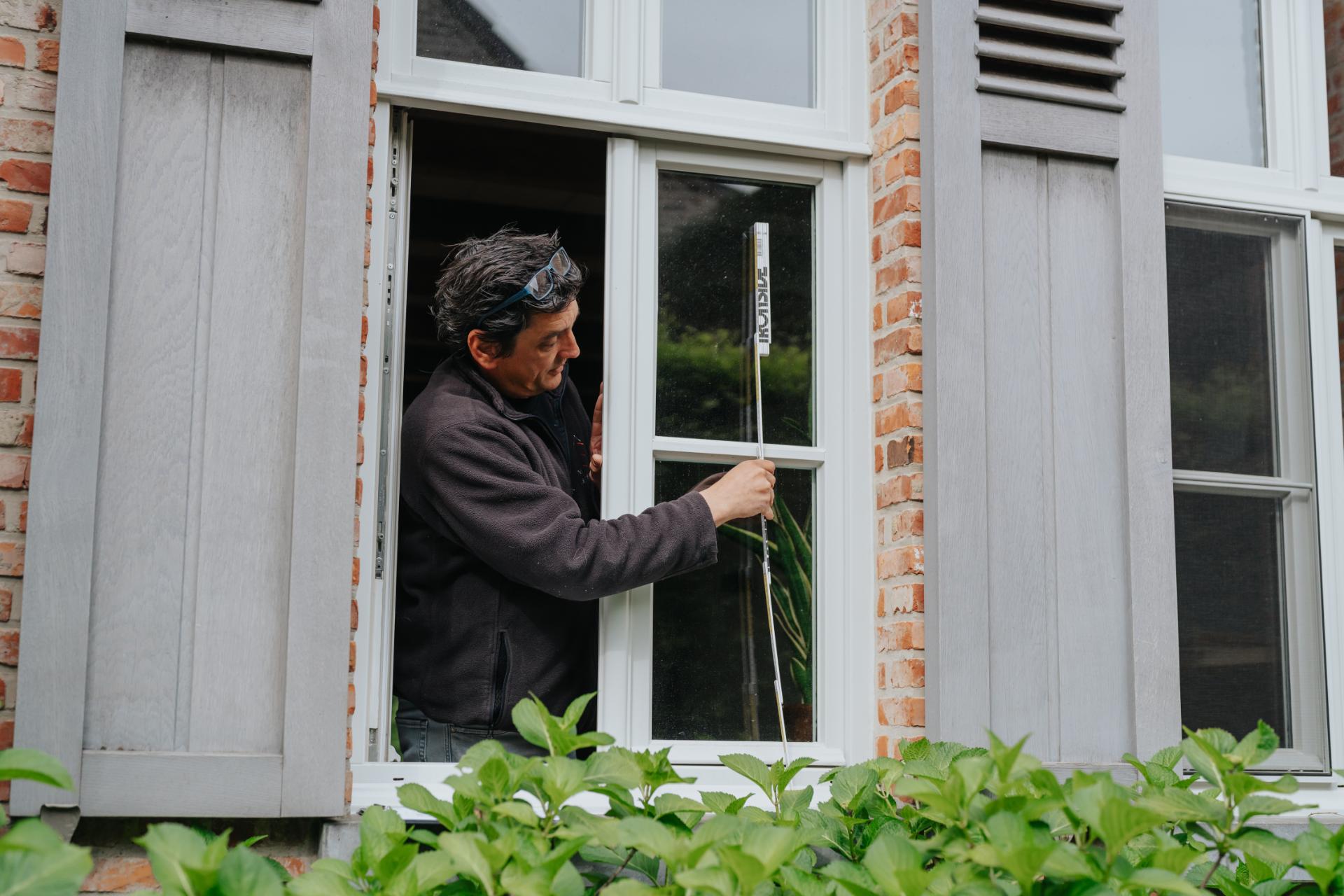 Expert inspecteert houten ramen van woning