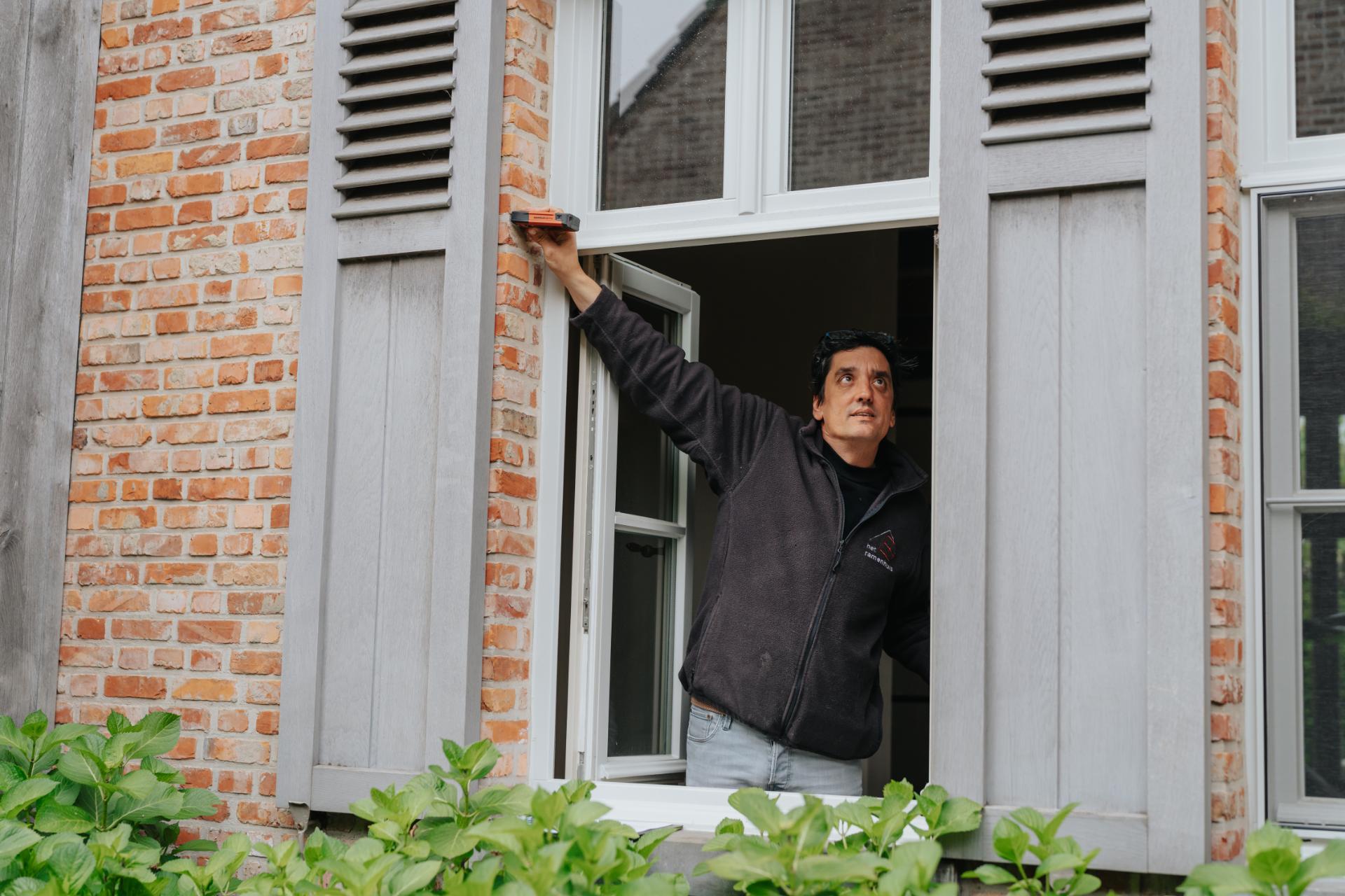Vakman controleert raamafmetingen aan gevel